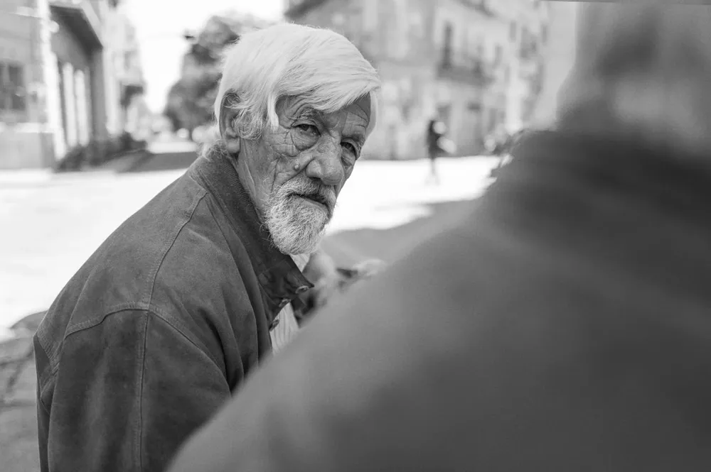 An older bearded man looks back over his shoulder