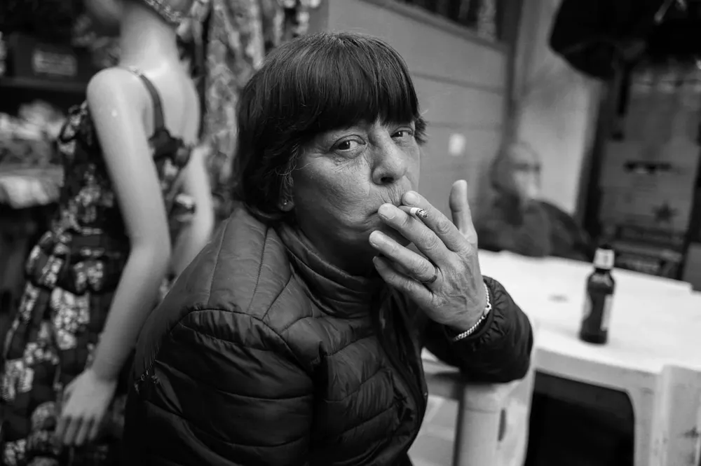 A woman smokes while seated outdoors