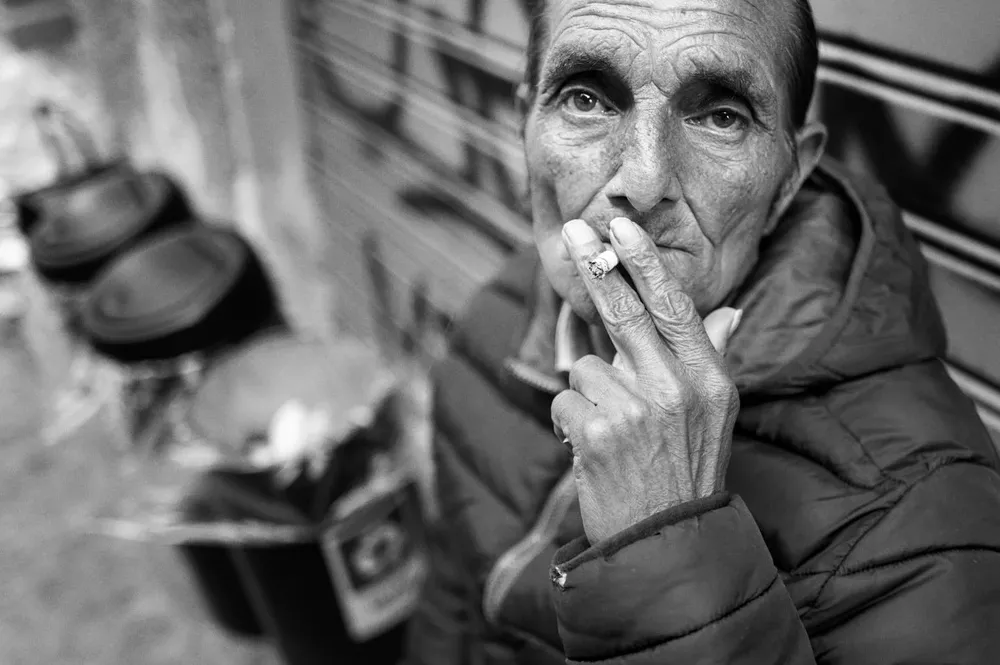 A man holds a cigarette close to his face