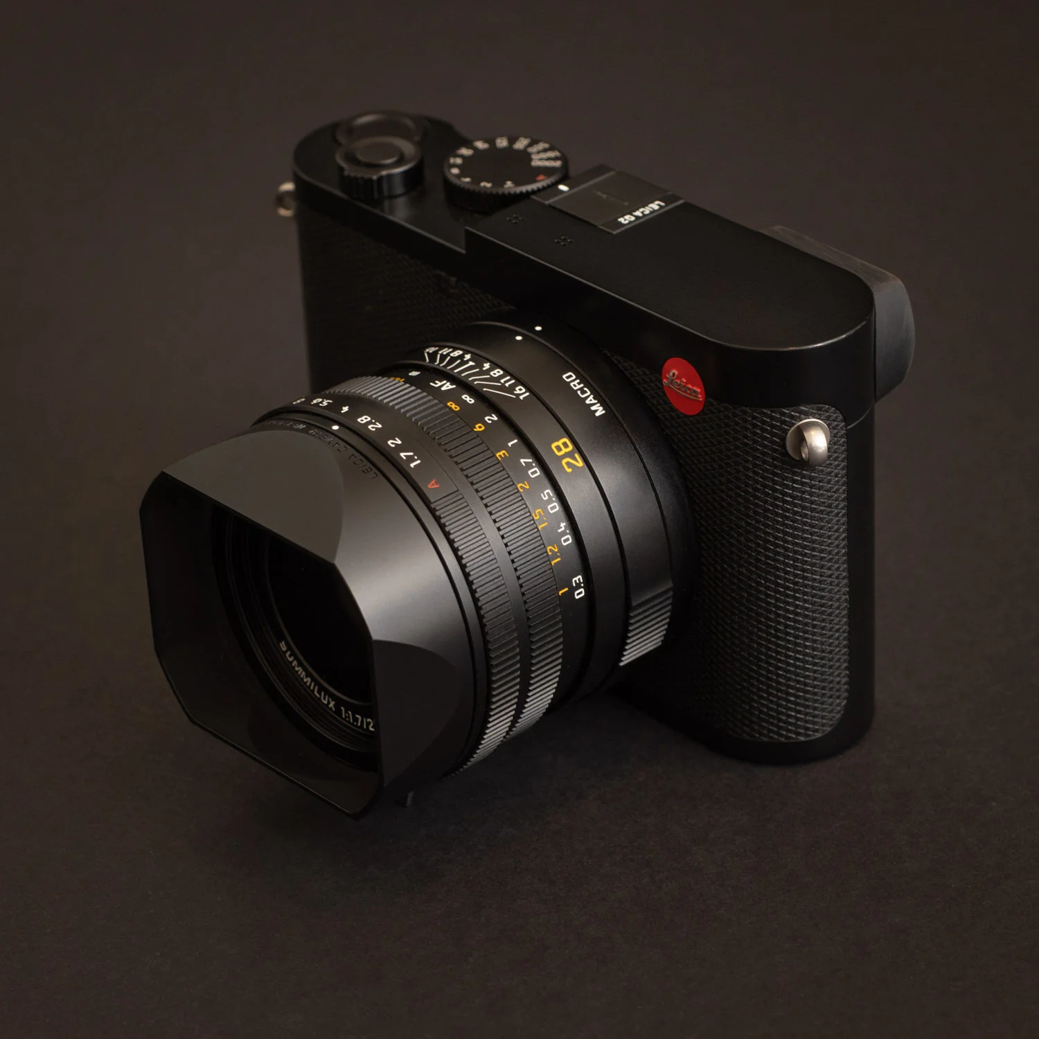 Black Leica camera with a large lens on a dark surface