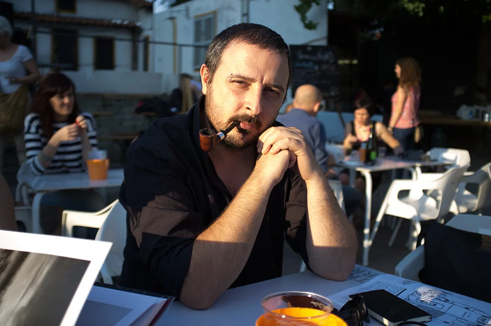 Eolo Perfido sits at an outdoor table