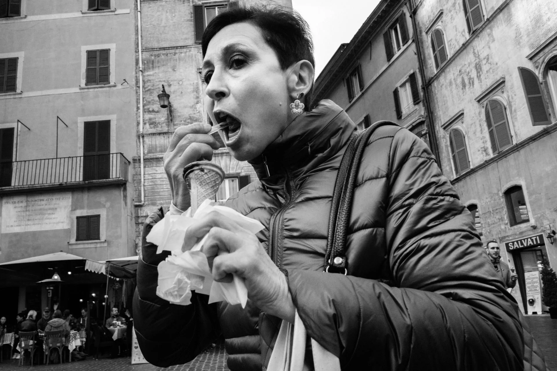 A man eats an ice cream while walking