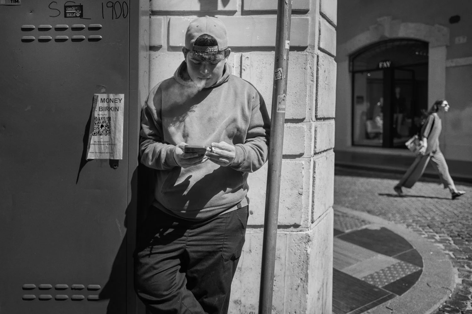 A man stands in a doorway holding an object in his hands