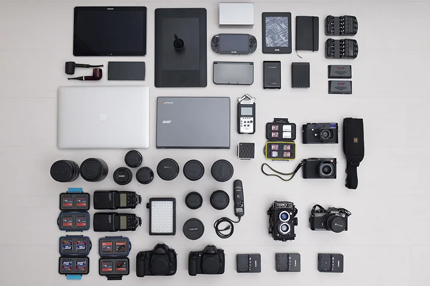 Cameras, lenses, computers and accessories arranged in a flat lay