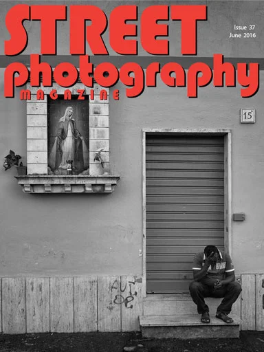 Street Photography Magazine cover with a seated man beneath a shutter