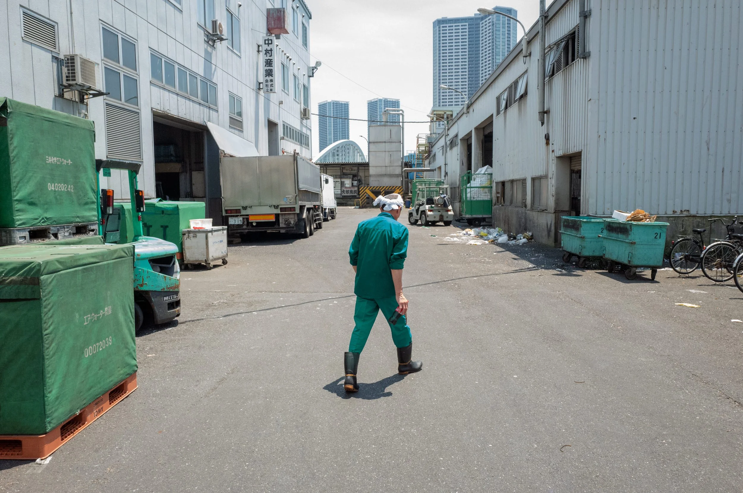 A worker in green walks down a service lane